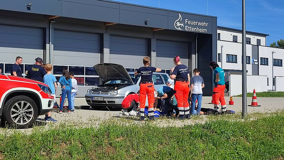Kinder üben zusammen mit dem DRK und der Feuerwehr das Verhalten bei einem Verkehrsunfall