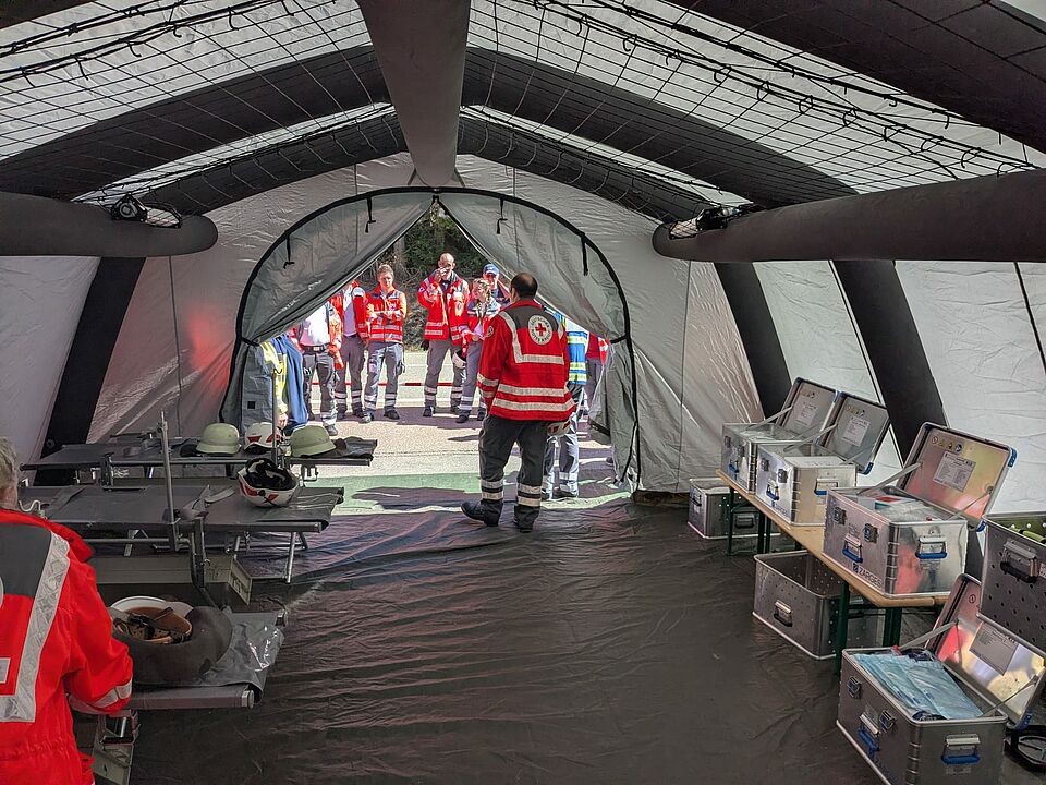 DRK Einsatzkräfte stehen in einem Behandlungszelt
