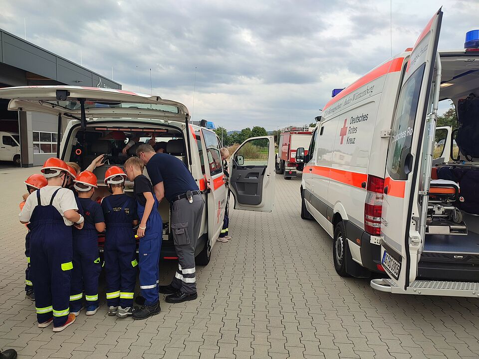 Löschzwerge Kinder der Jugendfeuerwehr bekommen ein Einsatzfahrzeug des DRK Ettenheim erklärt.