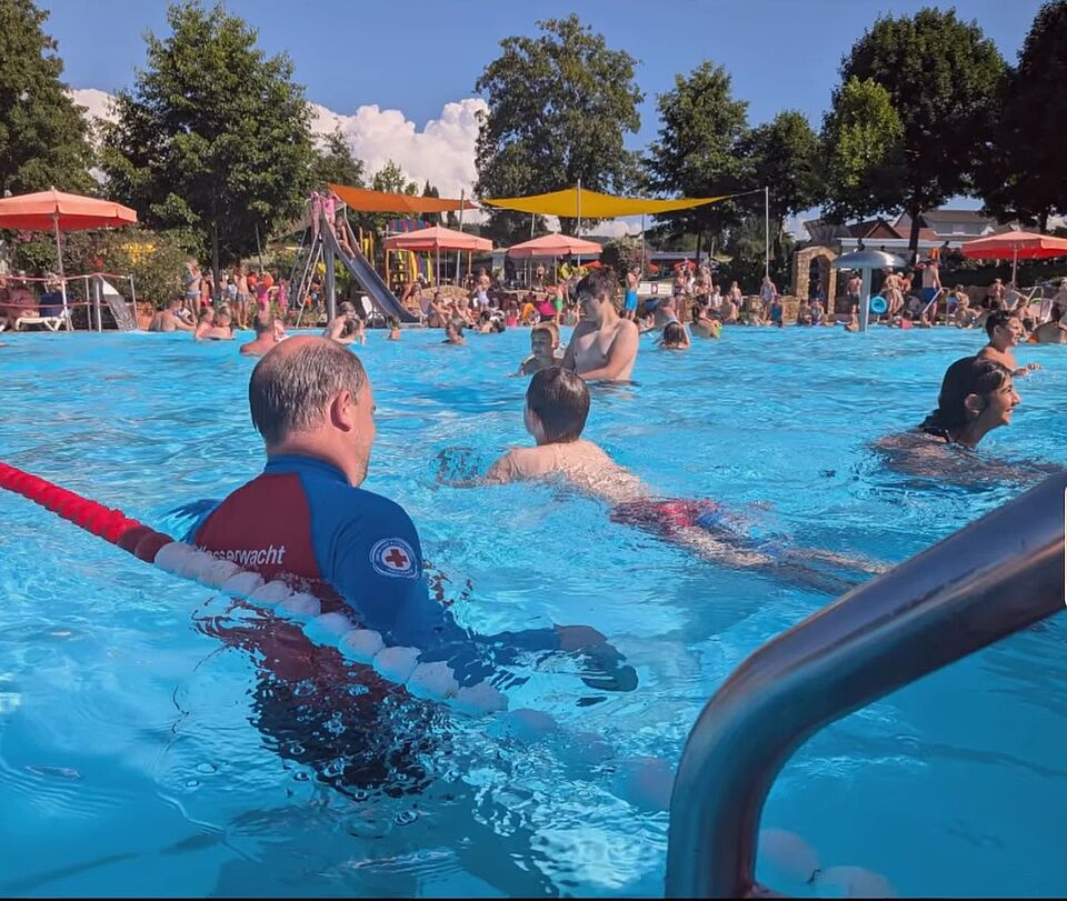 Rettungsschwimmer der Wasserwacht mit einem Kind im Wasser