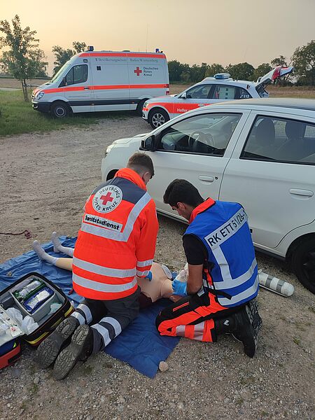 Zwei DRK Rettungssanitäter üben die Wiederbelebung bei einem Fallbeispiel